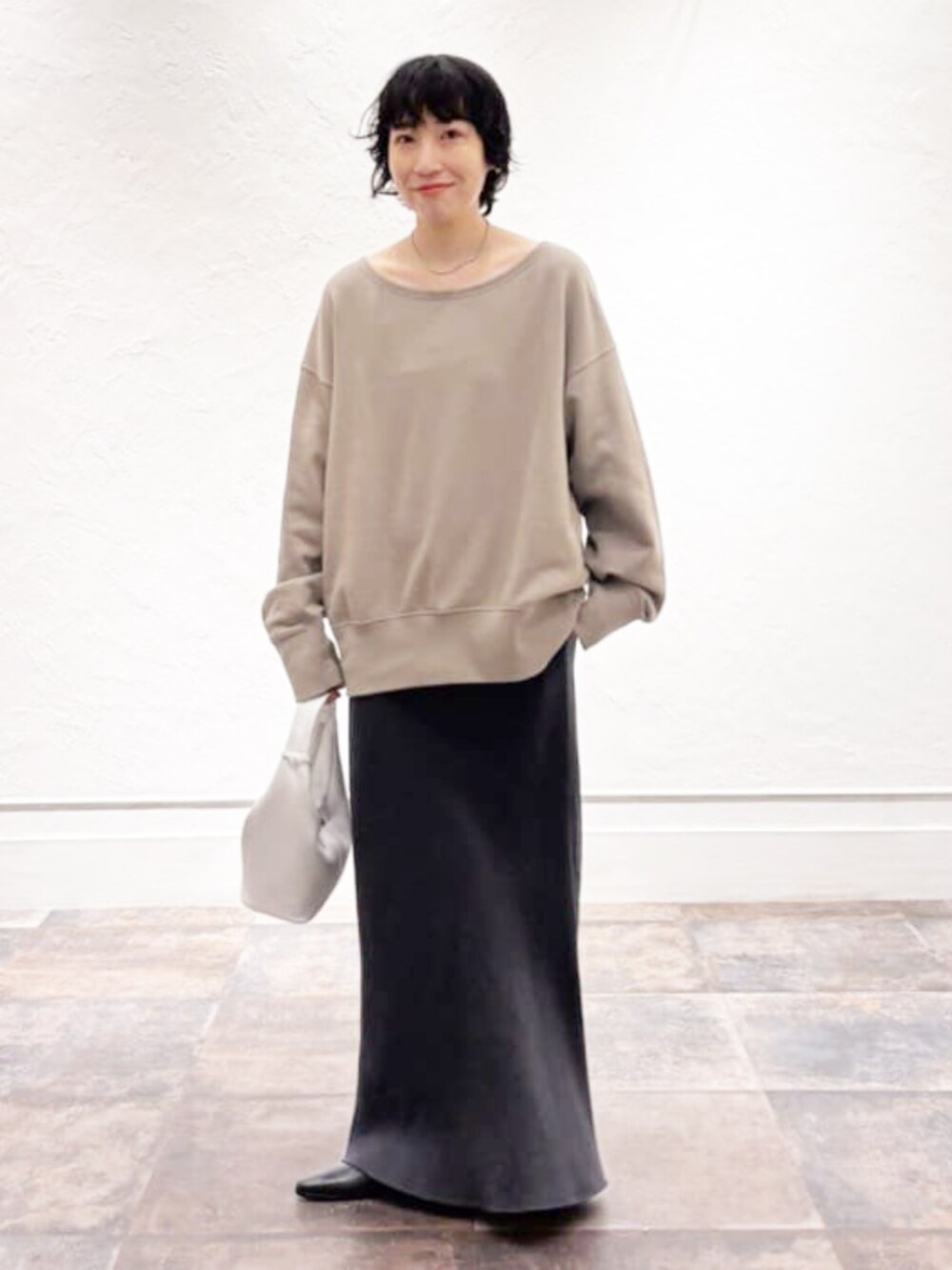 グレー系のスカート、グリーン系のスウェットを着用したレディースの夏コーディネートの1枚目の写真