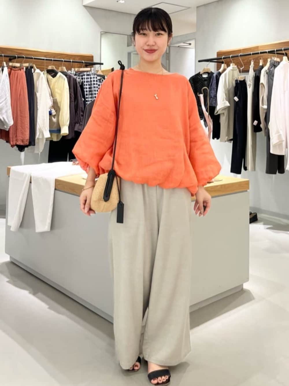 グレー系のその他パンツ、オレンジ系のシャツ/ブラウスを着用したレディースの春コーディネートの1枚目の写真