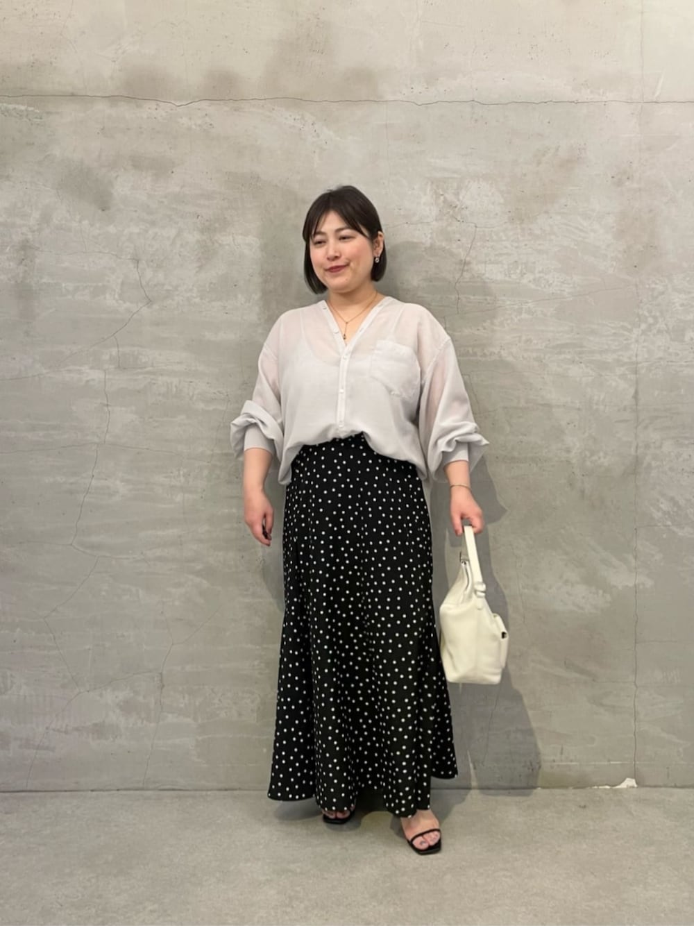 ブラック系のスカート、ホワイト系のトートバッグ、グレー系のシャツ/ブラウスを着用したレディースの冬コーディネートの1枚目の写真