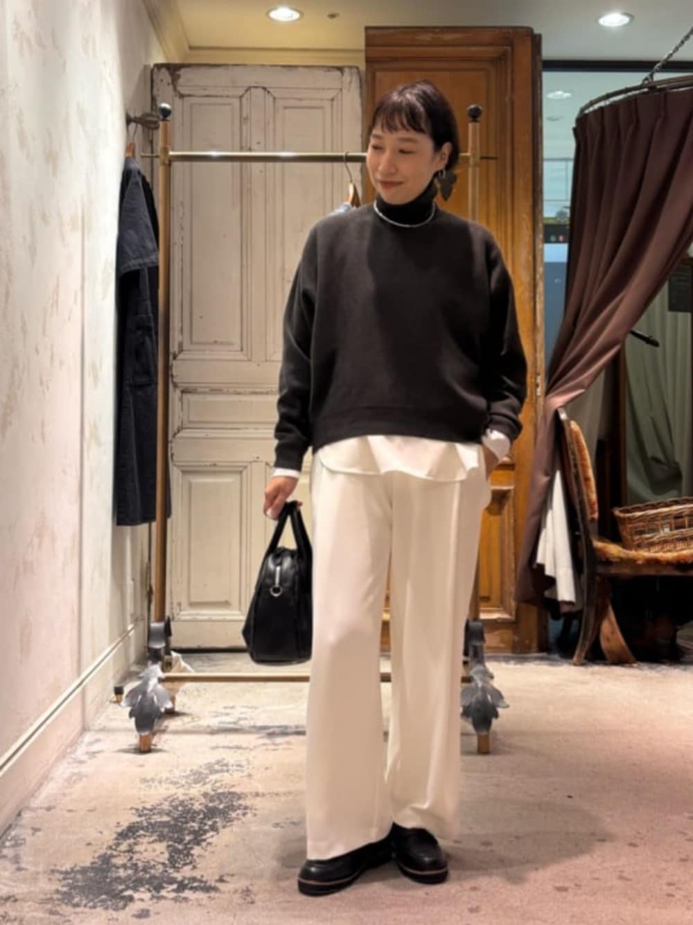 グレー系のニット/セーター、ブラック系のトートバッグ、ホワイト系のその他パンツを着用したレディースの秋コーディネートの1枚目の写真