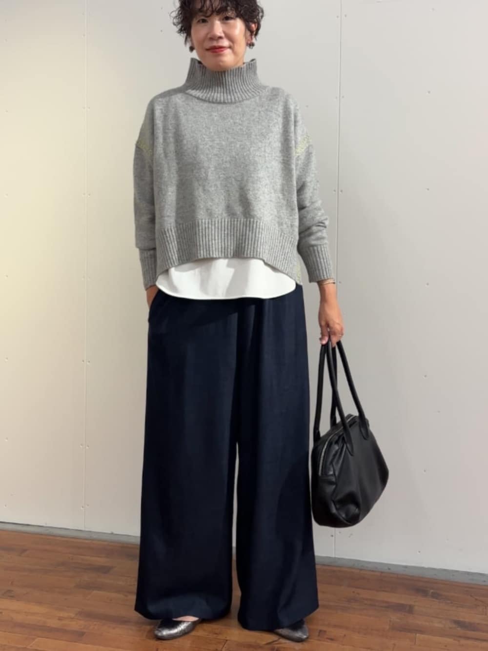 ブラック系のボストンバッグ、ブルー系のその他パンツ、グレー系のニット/セーターを着用したレディースの冬コーディネートの1枚目の写真