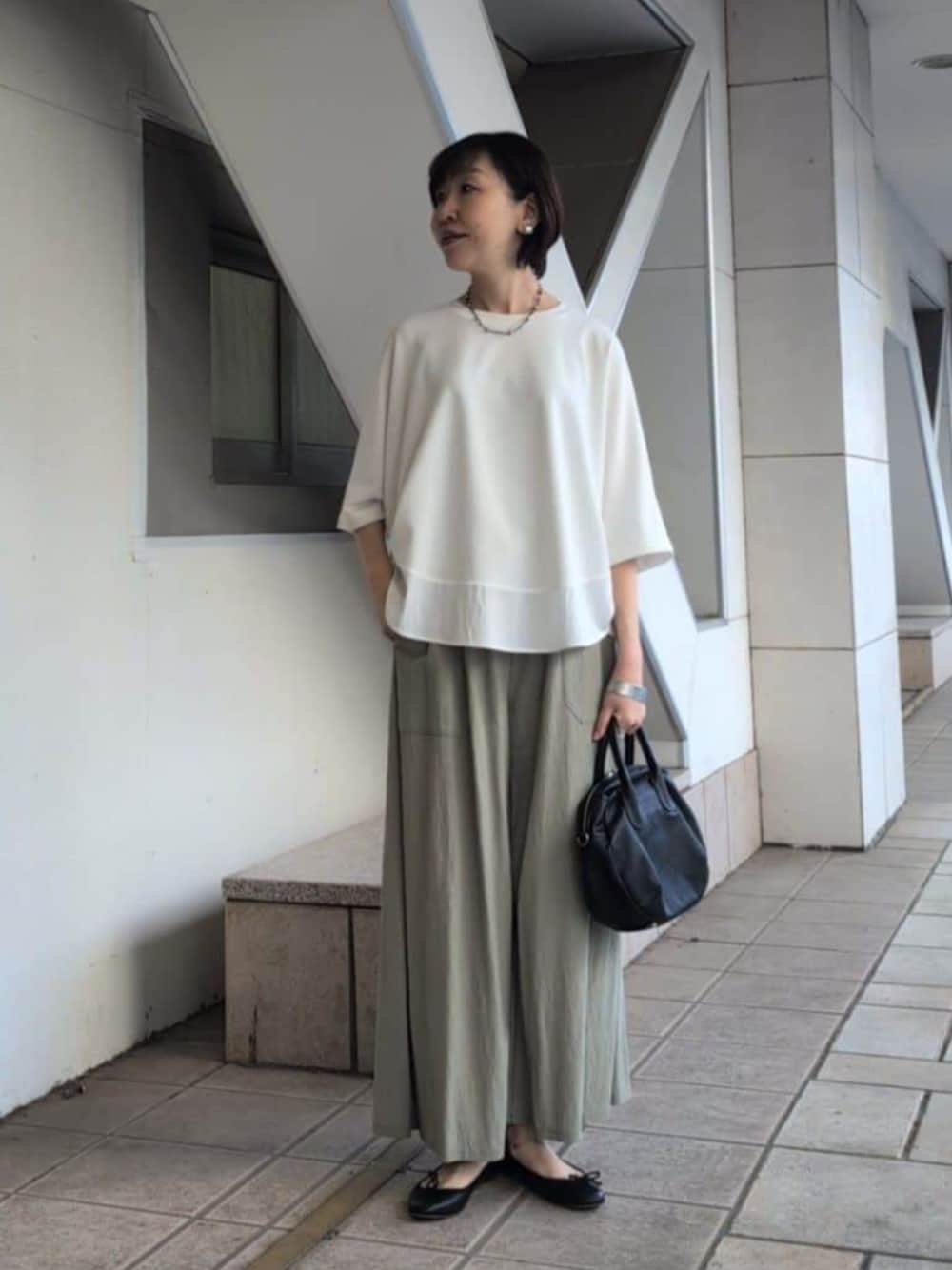 グリーン系のその他パンツ、ホワイト系のTシャツ/カットソーを着用したレディースの春コーディネートの1枚目の写真