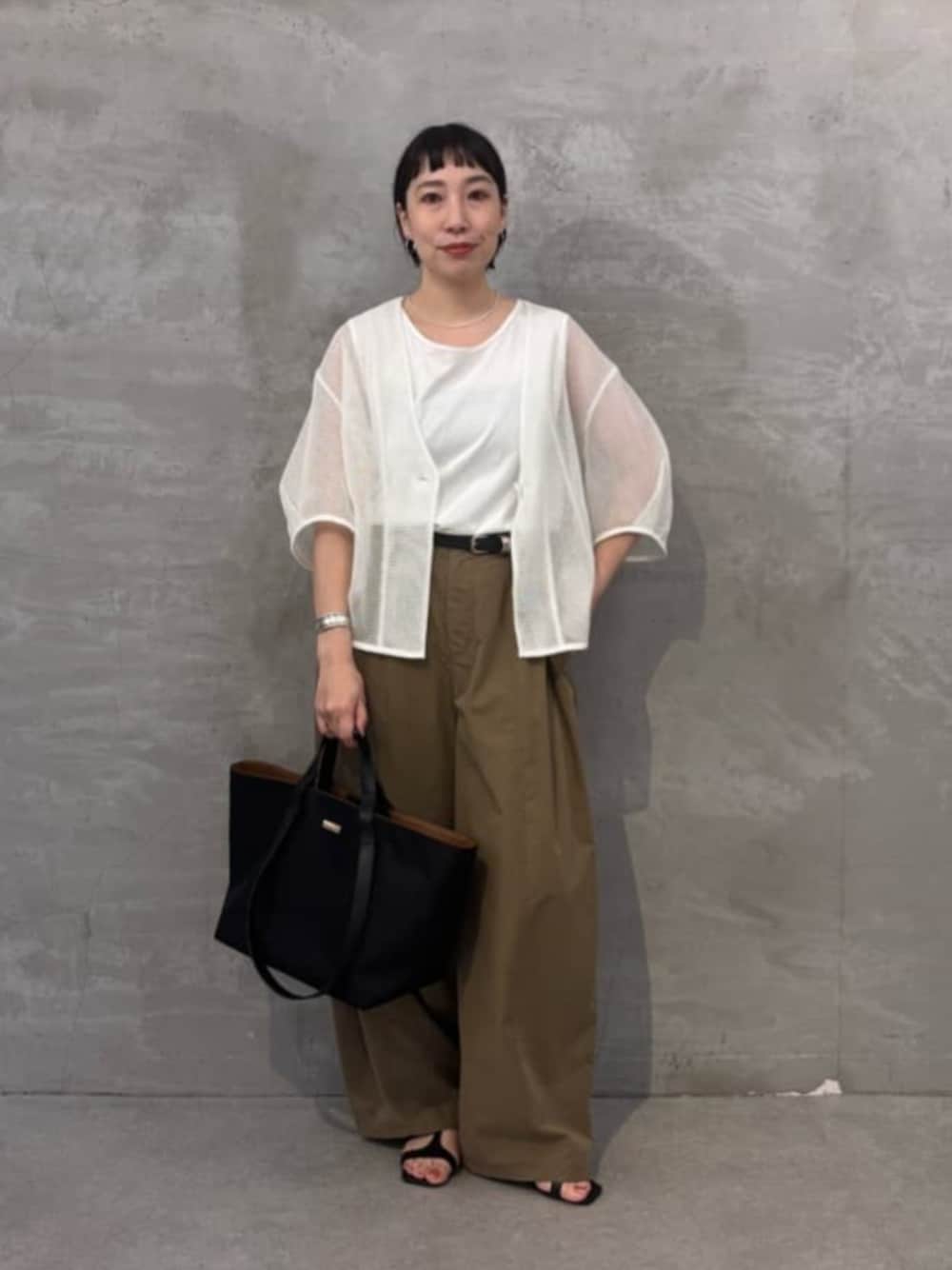 イエロー系のその他パンツ、ホワイト系のシャツ/ブラウス、ブラック系のトートバッグを着用したレディースの春コーディネートの1枚目の写真