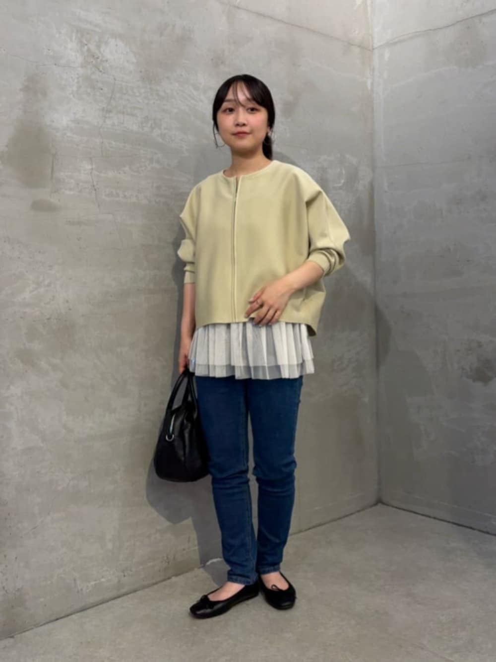 ホワイト系のキャミソール、ブルー系のデニムパンツ、ベージュ系のカーディガン/ボレロを着用したレディースの秋コーディネートの1枚目の写真