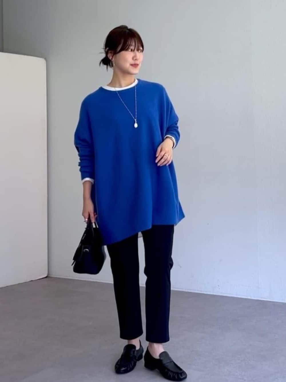 ブラック系のローファー、ブラック系のその他パンツ、ブルー系のニット/セーターを着用したレディースの秋コーディネートの1枚目の写真