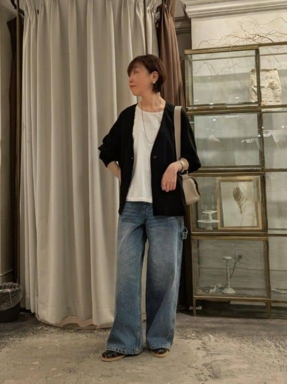 ホワイト系のタンクトップ、ベージュ系のショルダーバッグ、ブルー系のその他パンツを着用したレディースの春コーディネートの1枚目の写真