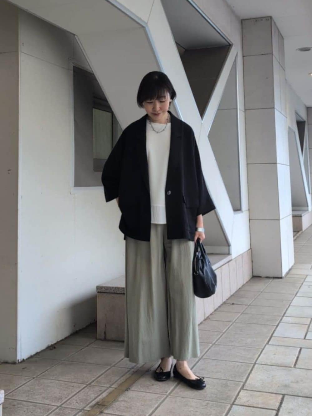 ブラック系のボストンバッグ、グリーン系のその他パンツ、ホワイト系のTシャツ/カットソーを着用したレディースの春コーディネートの1枚目の写真