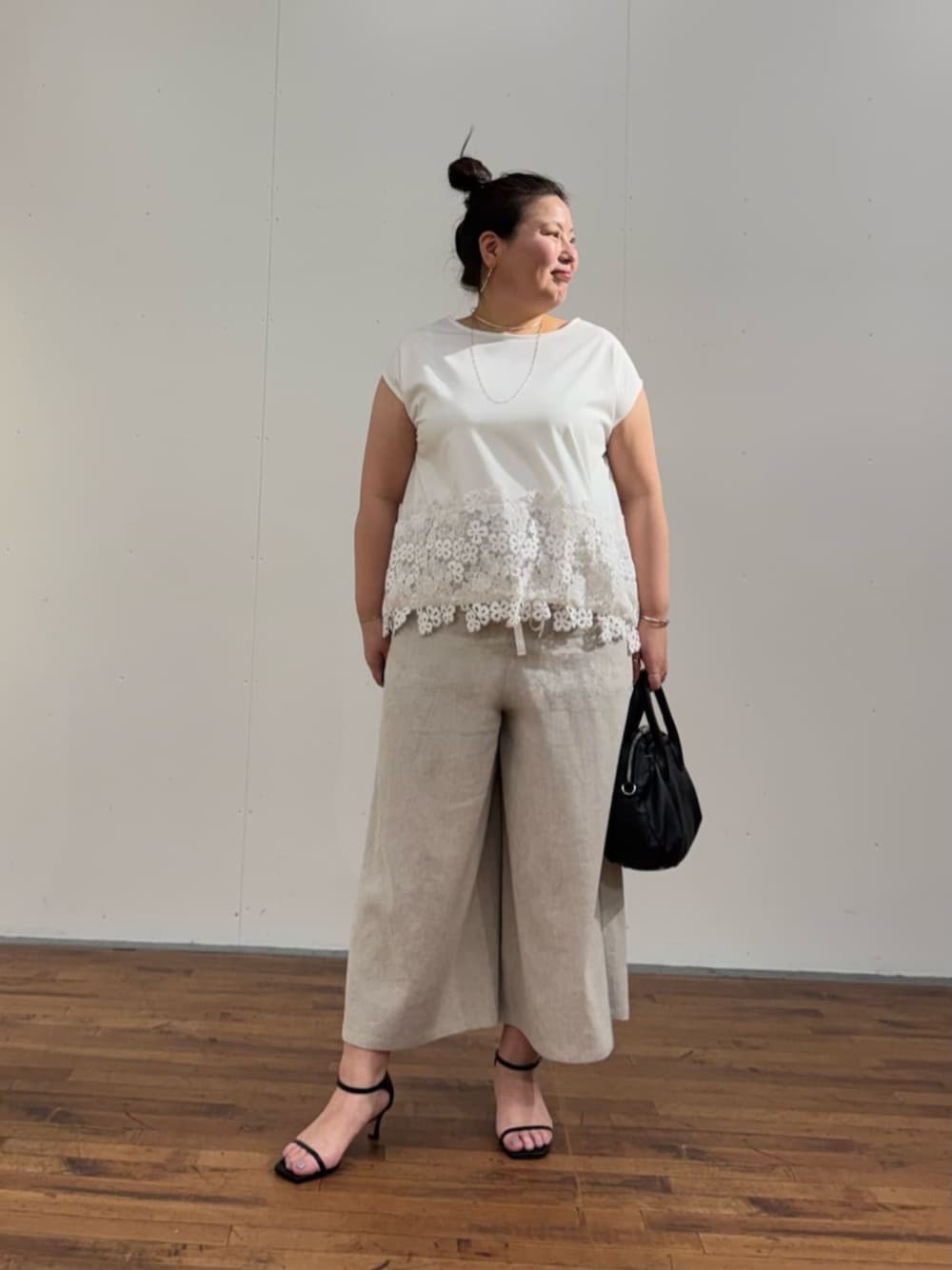 ブラック系のボストンバッグ、ホワイト系のTシャツ/カットソー、ベージュ系のその他パンツを着用したレディースの春コーディネートの1枚目の写真