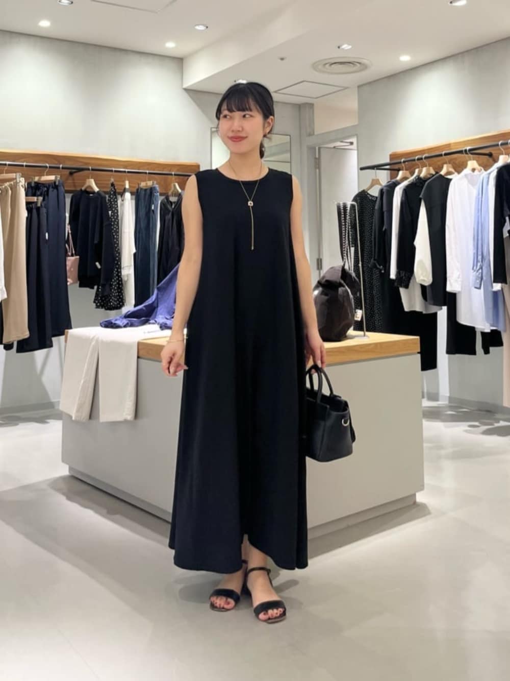 ブラック系のハンドバッグ、ブラック系のワンピースを着用したレディースの春コーディネートの1枚目の写真