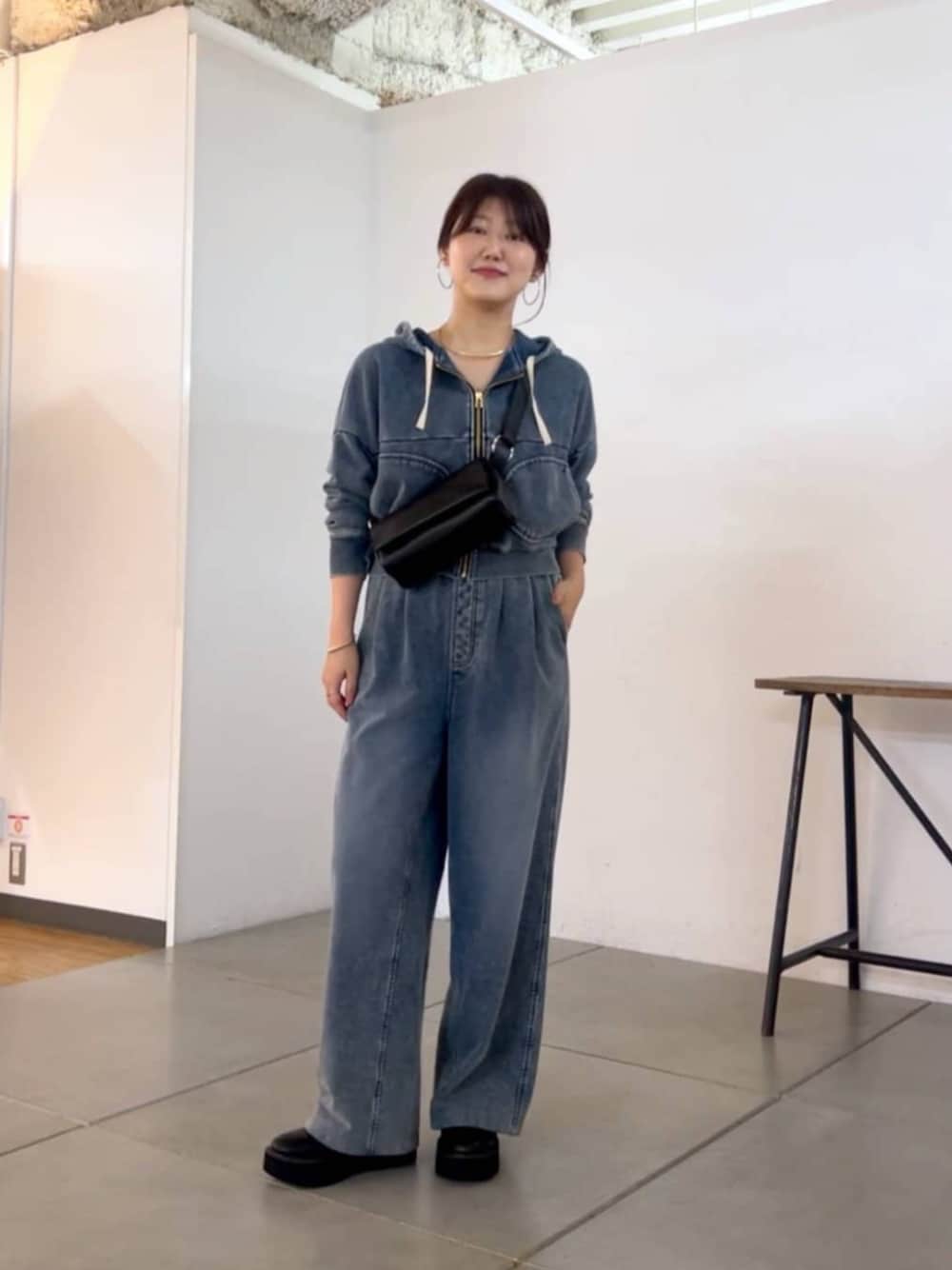 ブラック系のショルダーバッグ、ブルー系のその他パンツ、ブルー系のパーカーを着用したレディースの秋コーディネートの1枚目の写真