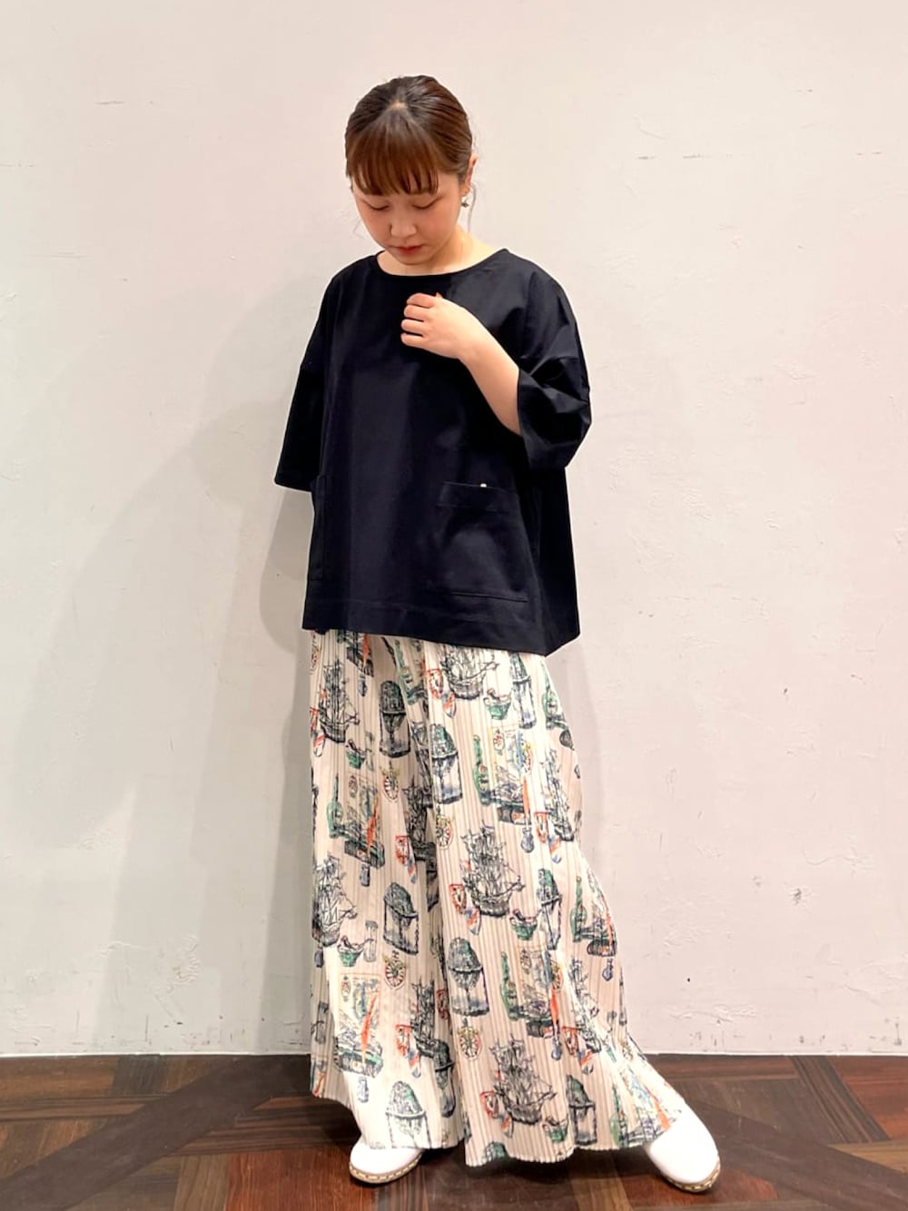 ブラック系のTシャツ/カットソー、ベージュ系のその他パンツ、ホワイト系のその他シューズを着用したレディースの春コーディネートの1枚目の写真