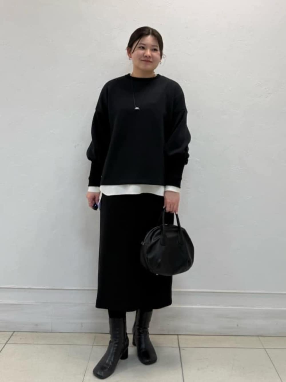 ホワイト系のシャツ/ブラウス、ブラック系のスカート、ブラック系のTシャツ/カットソーを着用したレディースの冬コーディネートの1枚目の写真