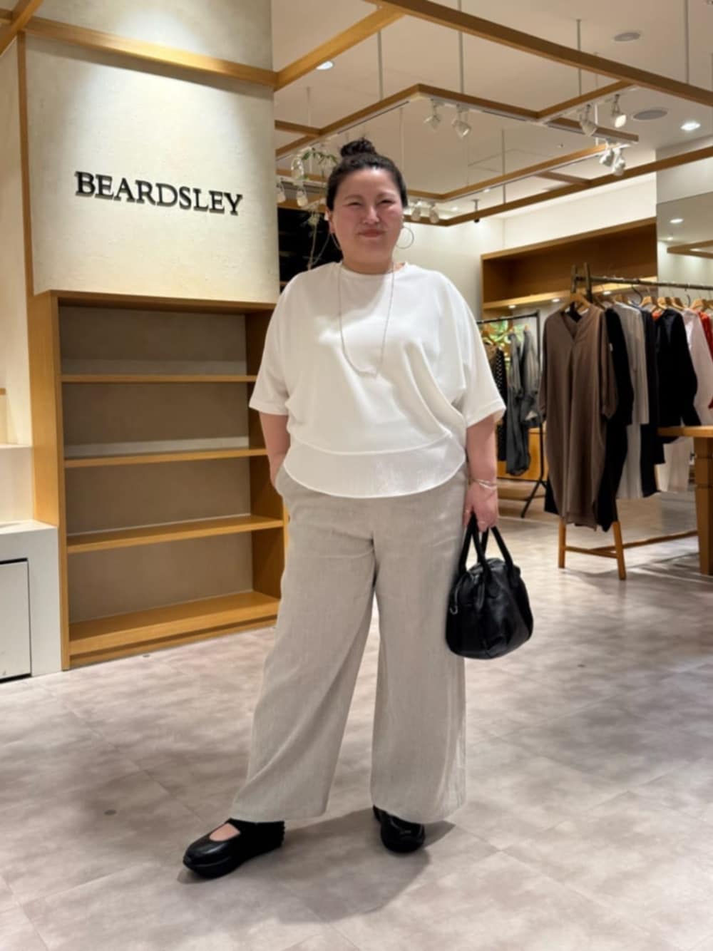 ブラック系のボストンバッグ、ベージュ系のその他パンツ、ホワイト系のTシャツ/カットソーを着用したレディースの春コーディネートの1枚目の写真