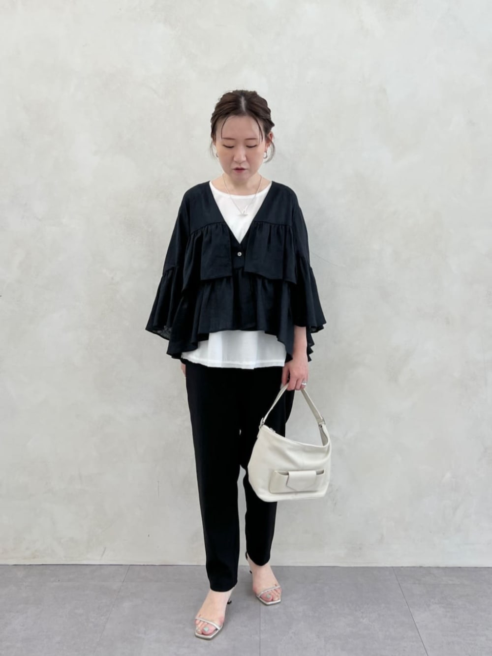 ホワイト系のトートバッグ、ブラック系のその他パンツ、ホワイト系のシャツ/ブラウスを着用したレディースの春コーディネートの1枚目の写真