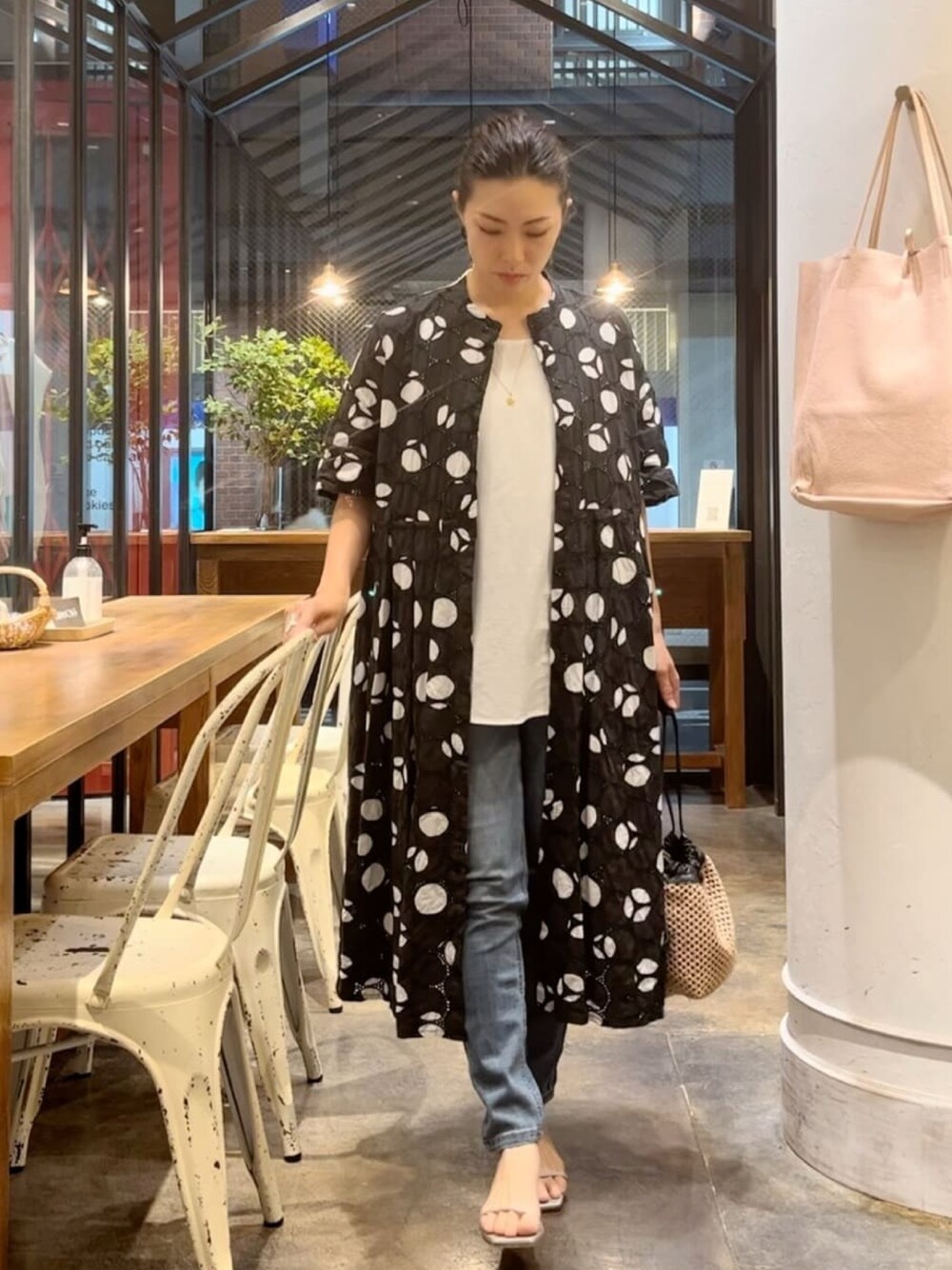 ブラック系のシャツワンピース、ホワイト系のシャツ/ブラウス、ブラック系のピアス(両耳用)を着用したレディースの夏コーディネートの1枚目の写真