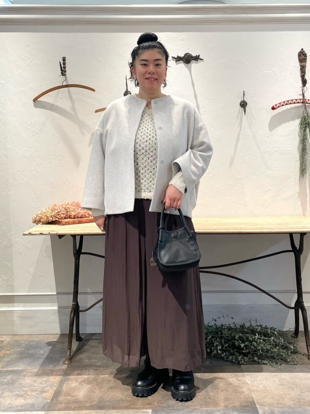 ブラウン系のその他パンツ、ホワイト系のニット/セーター、グレー系のノーカラーコートを着用したレディースの冬コーディネートの1枚目の写真