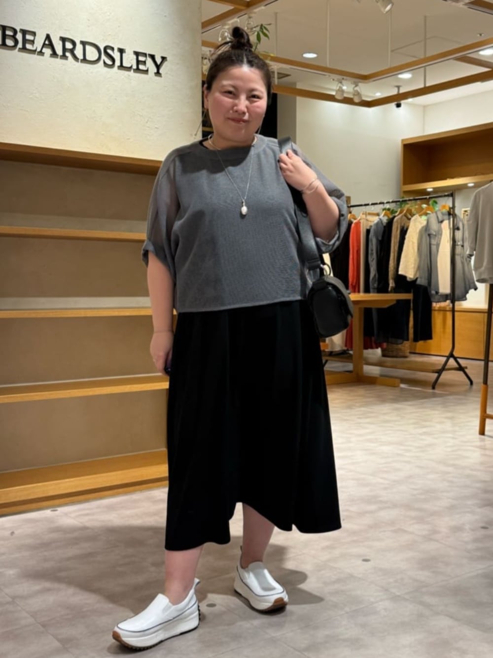 ホワイト系のスニーカー、ブラック系のワンピース、グレー系のTシャツ/カットソーを着用したレディースの夏コーディネートの1枚目の写真