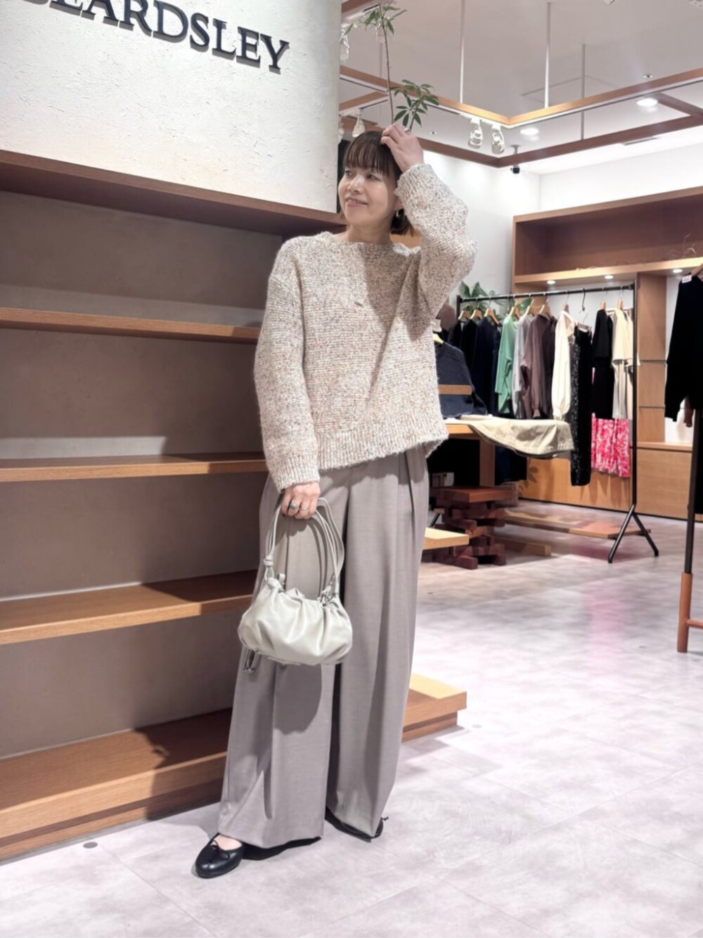 ベージュ系のショルダーバッグ、ピンク系のニット/セーター、ベージュ系のその他パンツを着用したレディースの秋コーディネートの1枚目の写真