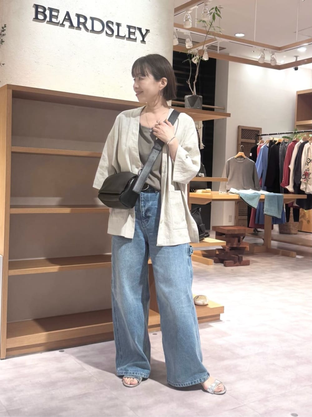 ブラック系のショルダーバッグ、ブルー系のその他パンツ、ブラウン系のキャミソールを着用したレディースの春コーディネートの1枚目の写真