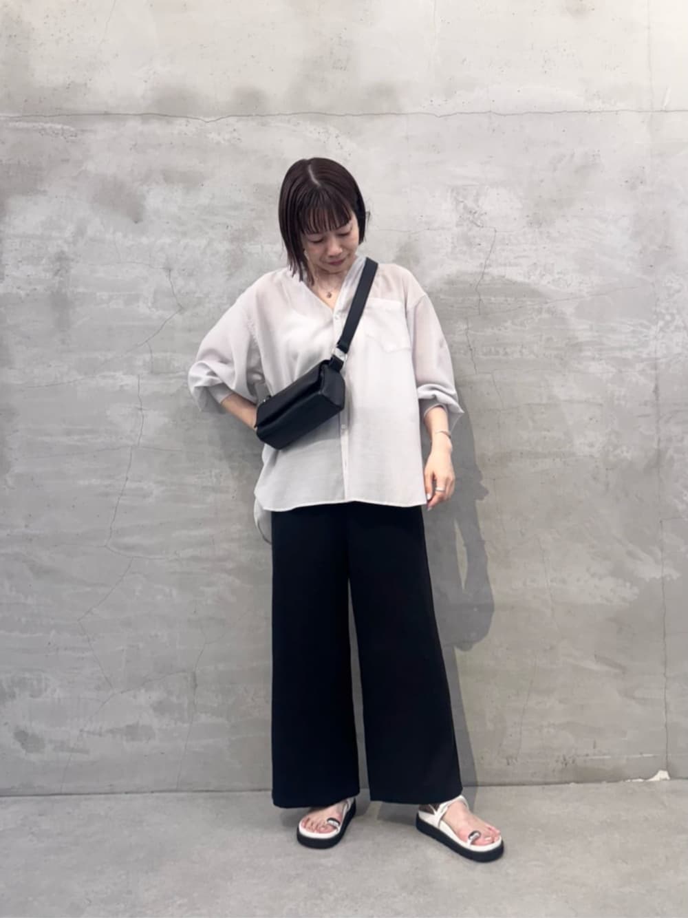 ブラック系のその他パンツ、ブラック系のショルダーバッグ、ホワイト系のサンダルを着用したレディースの冬コーディネートの1枚目の写真