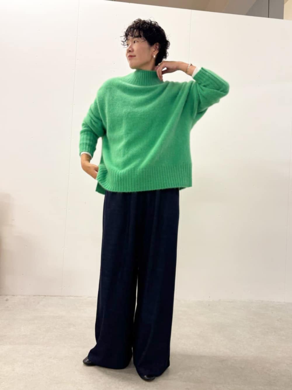 グリーン系のニット/セーター、ブルー系のその他パンツを着用したレディースの秋コーディネートの1枚目の写真