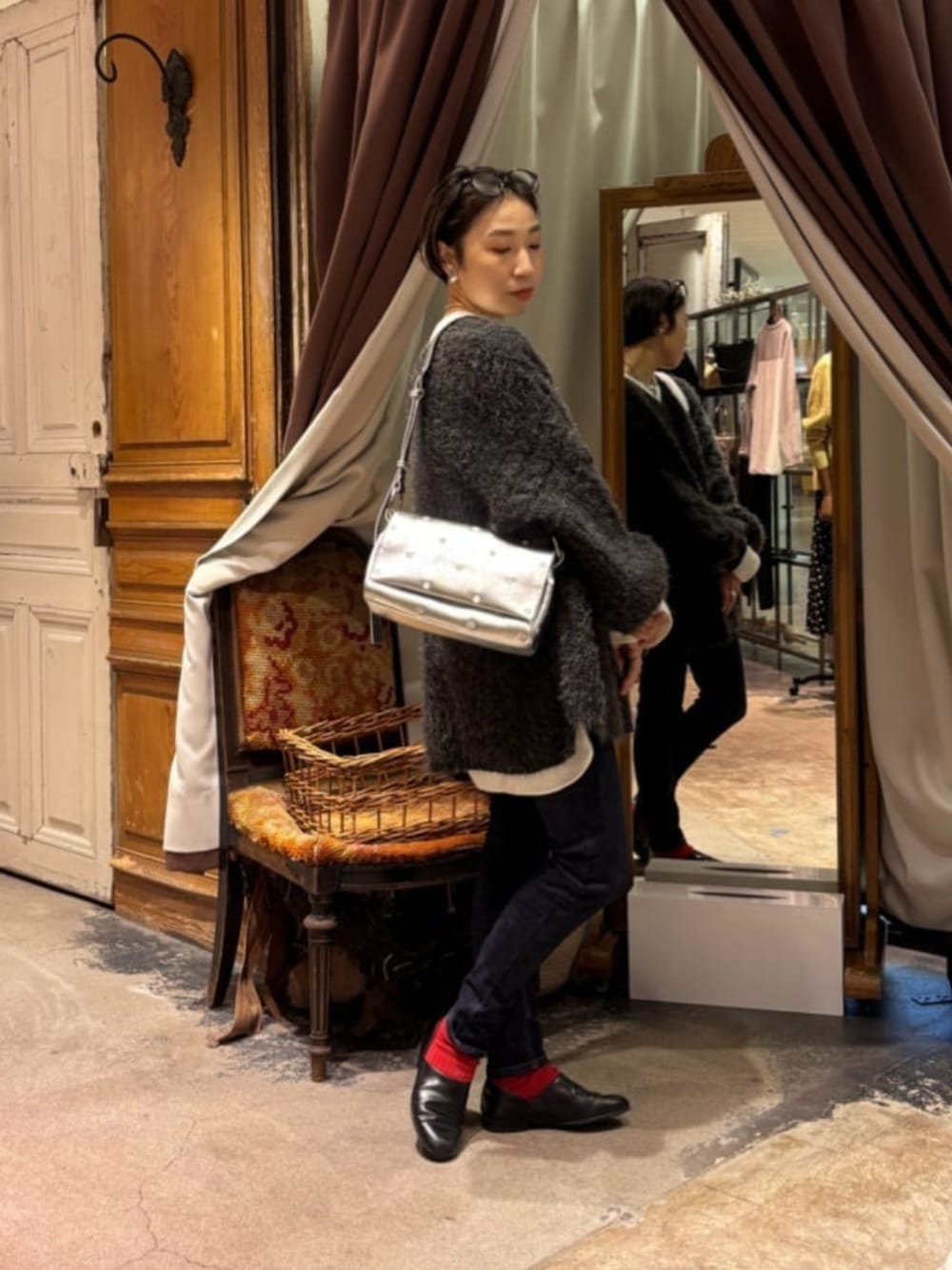 ブルー系のデニムパンツ、シルバー系のショルダーバッグを着用したレディースの秋コーディネートの1枚目の写真