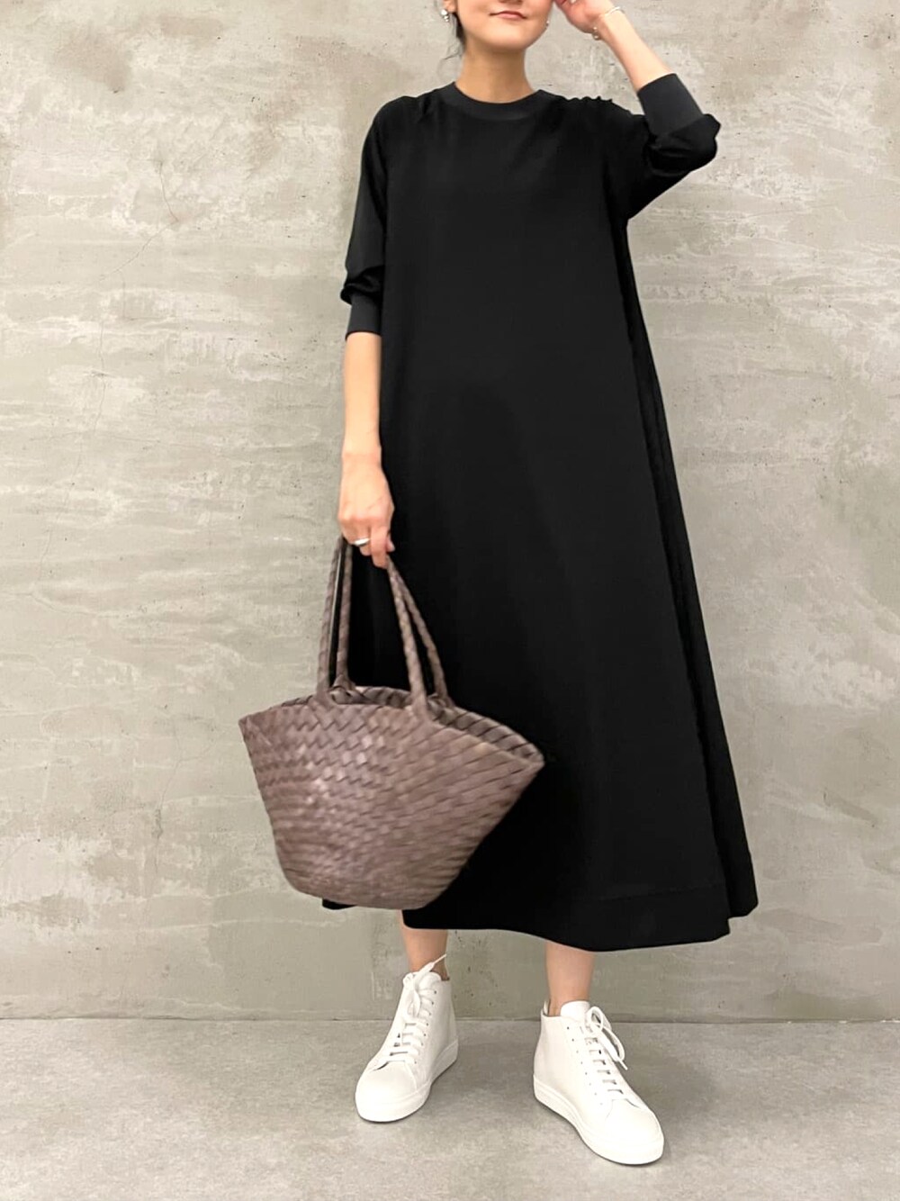 ブラック系のワンピース、ホワイト系のスニーカーを着用したレディースの春コーディネートの1枚目の写真