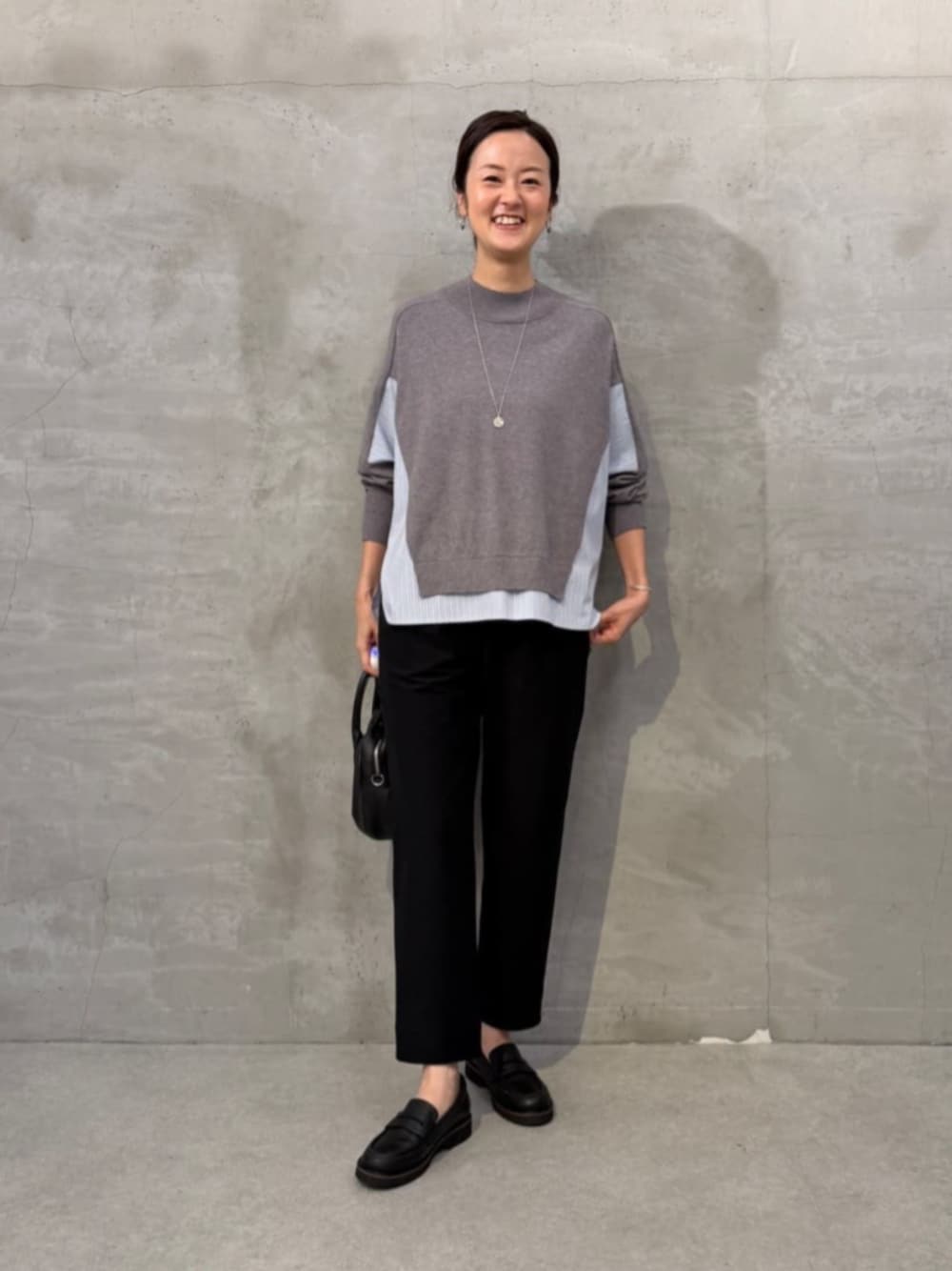 グレー系のニット/セーター、ブラック系のその他パンツ、ブラック系のローファーを着用したレディースの秋コーディネートの1枚目の写真