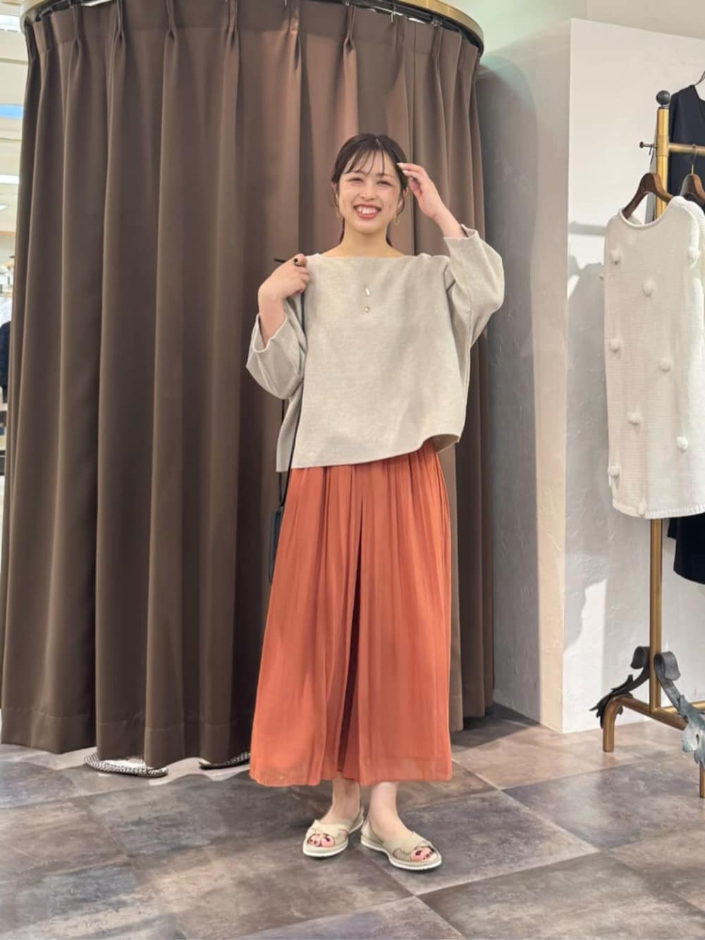 オレンジ系のその他パンツ、ベージュ系のニット/セーターを着用したレディースの春コーディネートの1枚目の写真