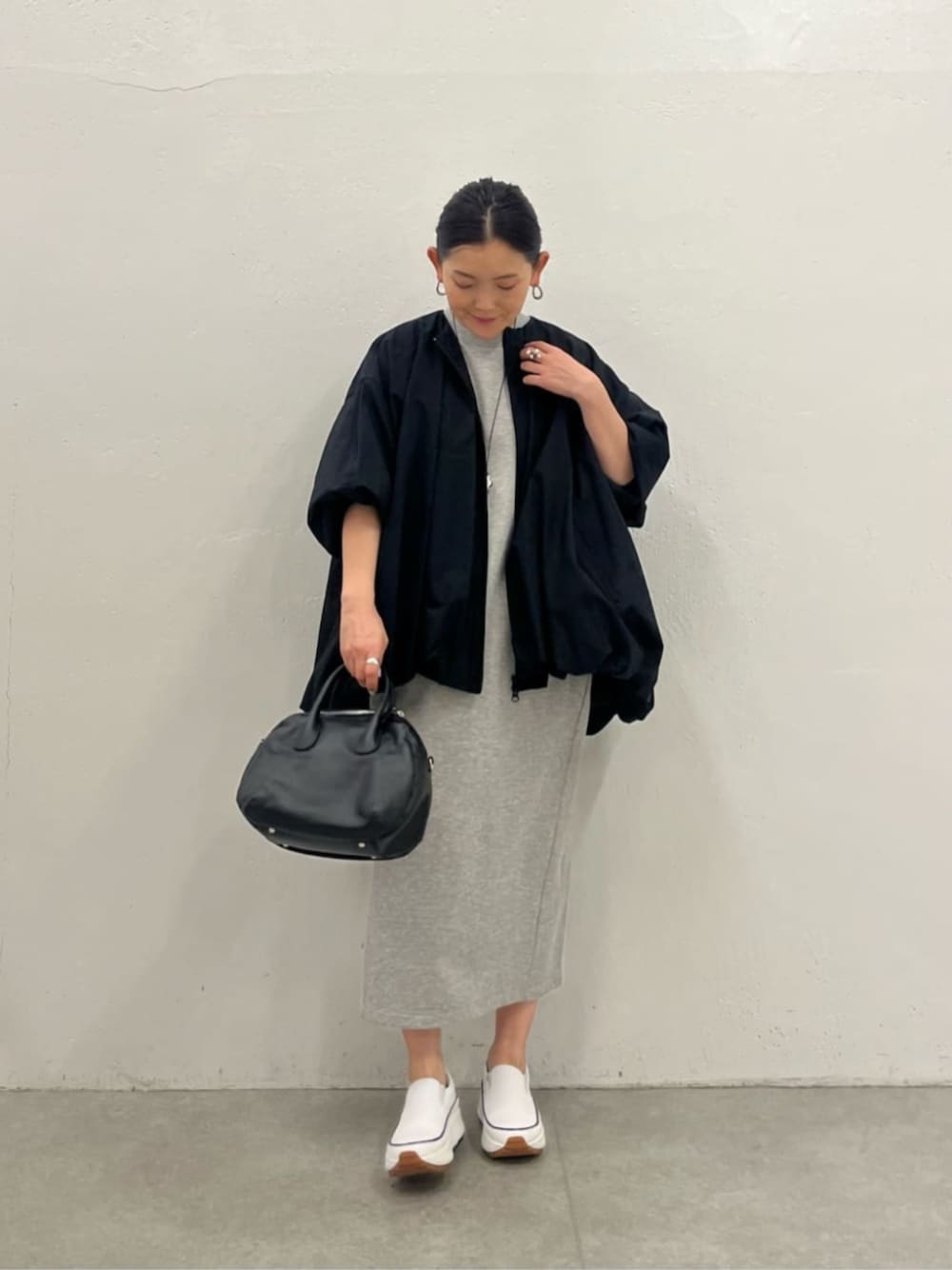 ブラック系のブルゾン、グレー系のワンピースを着用したレディースの冬コーディネートの1枚目の写真