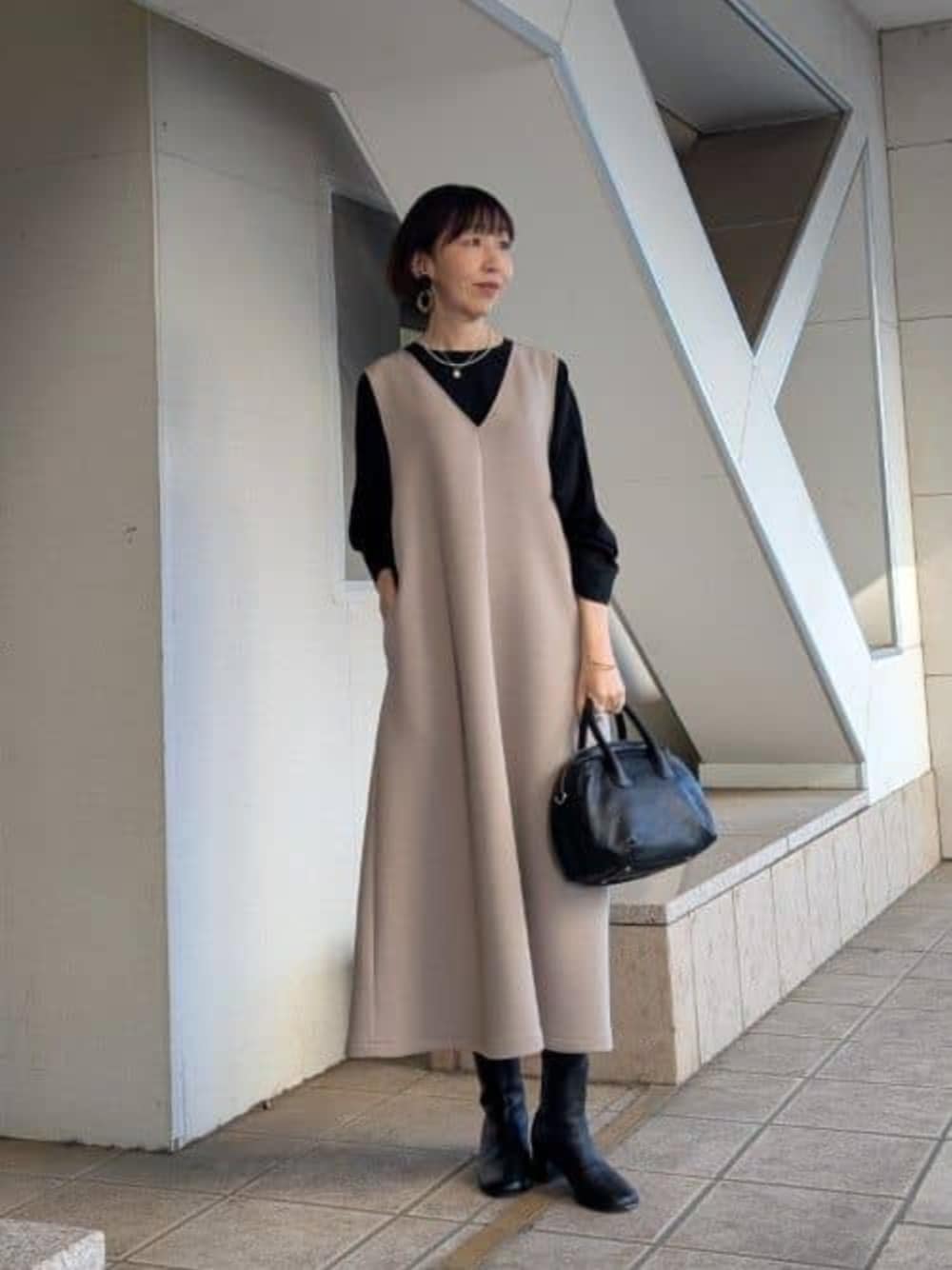 ブラック系のシャツ/ブラウス、ブラウン系のジャンパースカート、シルバー系のネックレスを着用したレディースの冬コーディネートの1枚目の写真