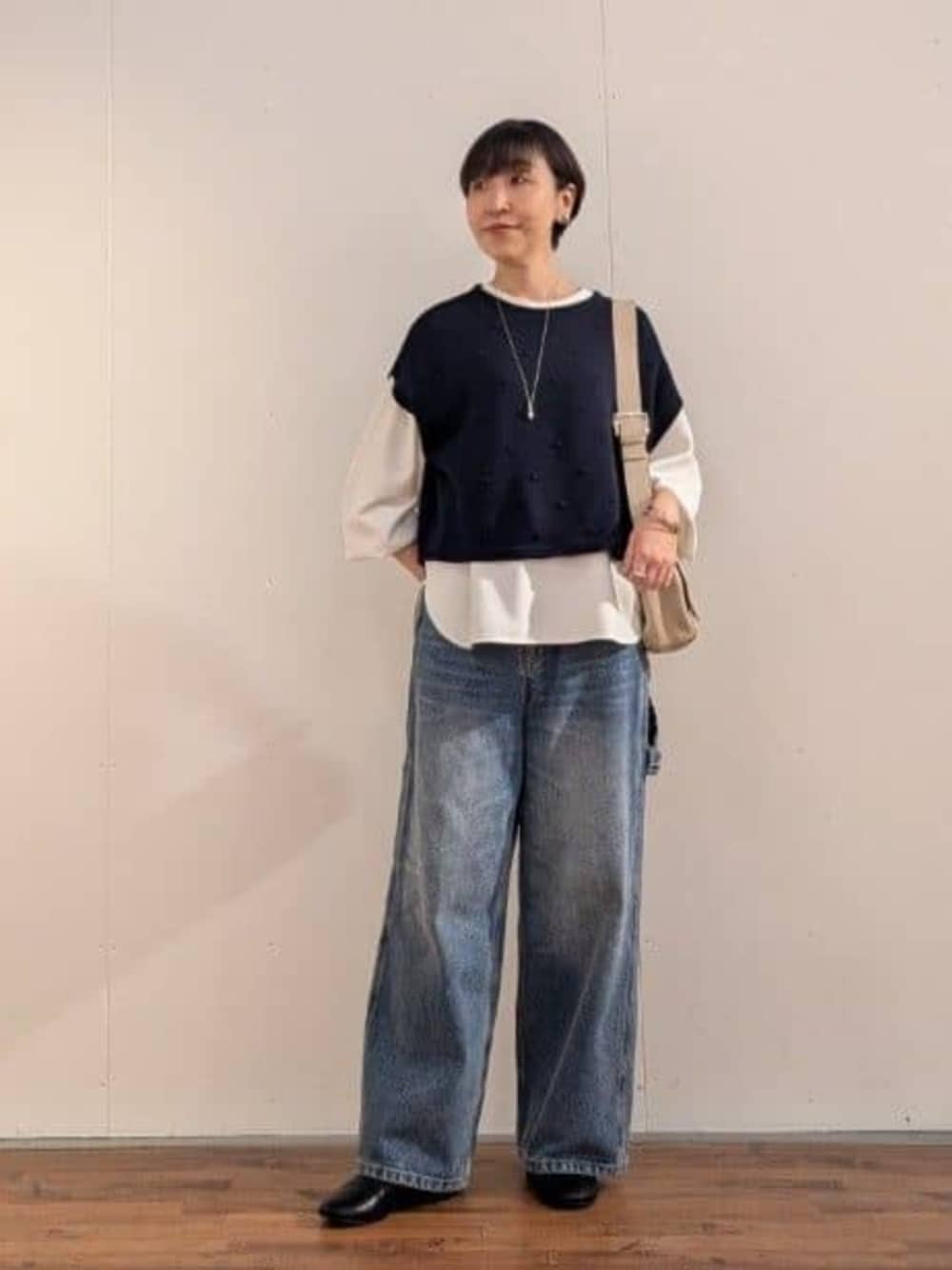 ブルー系のデニムパンツ、ホワイト系のシャツ/ブラウス、ブルー系のベストを着用したレディースの秋コーディネートの1枚目の写真