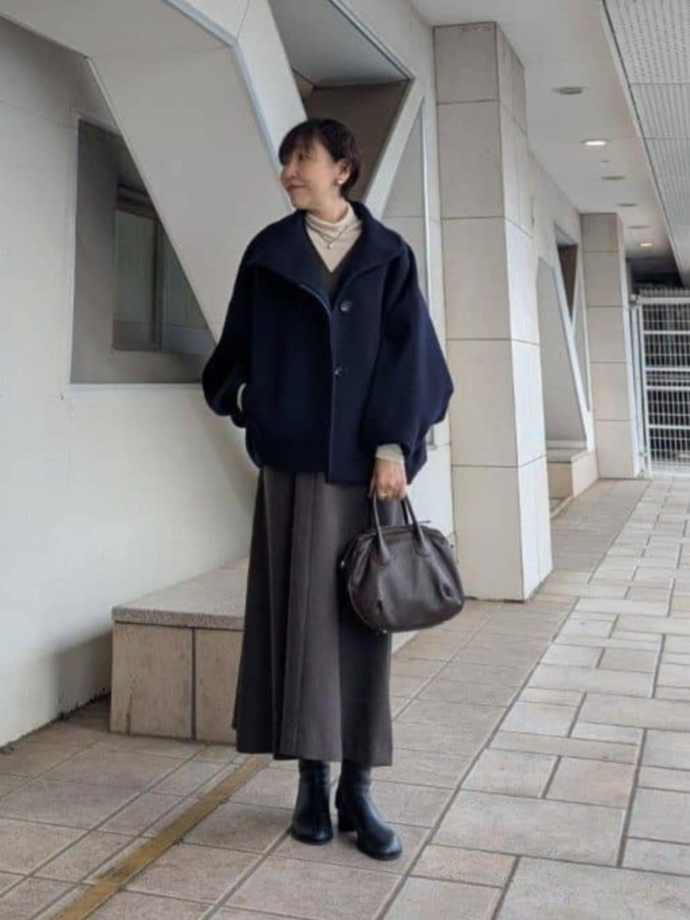 ブラック系のブーツ、ブルー系のその他アウターを着用したレディースの秋コーディネートの1枚目の写真