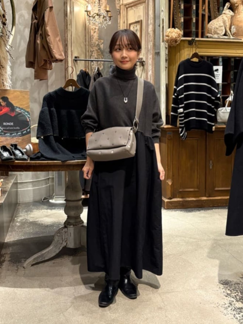 グレー系のワンピース、グレー系のショルダーバッグを着用したレディースの冬コーディネートの1枚目の写真