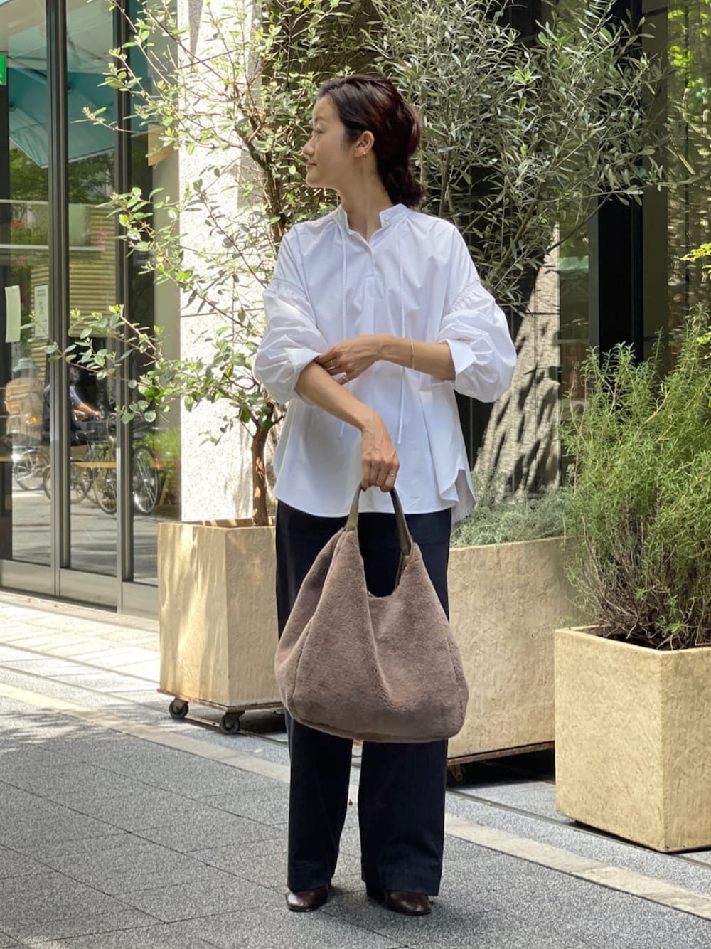 ホワイト系のシャツ/ブラウス、ブルー系のデニムパンツ、ブラウン系のトートバッグを着用したレディースの夏コーディネートの1枚目の写真