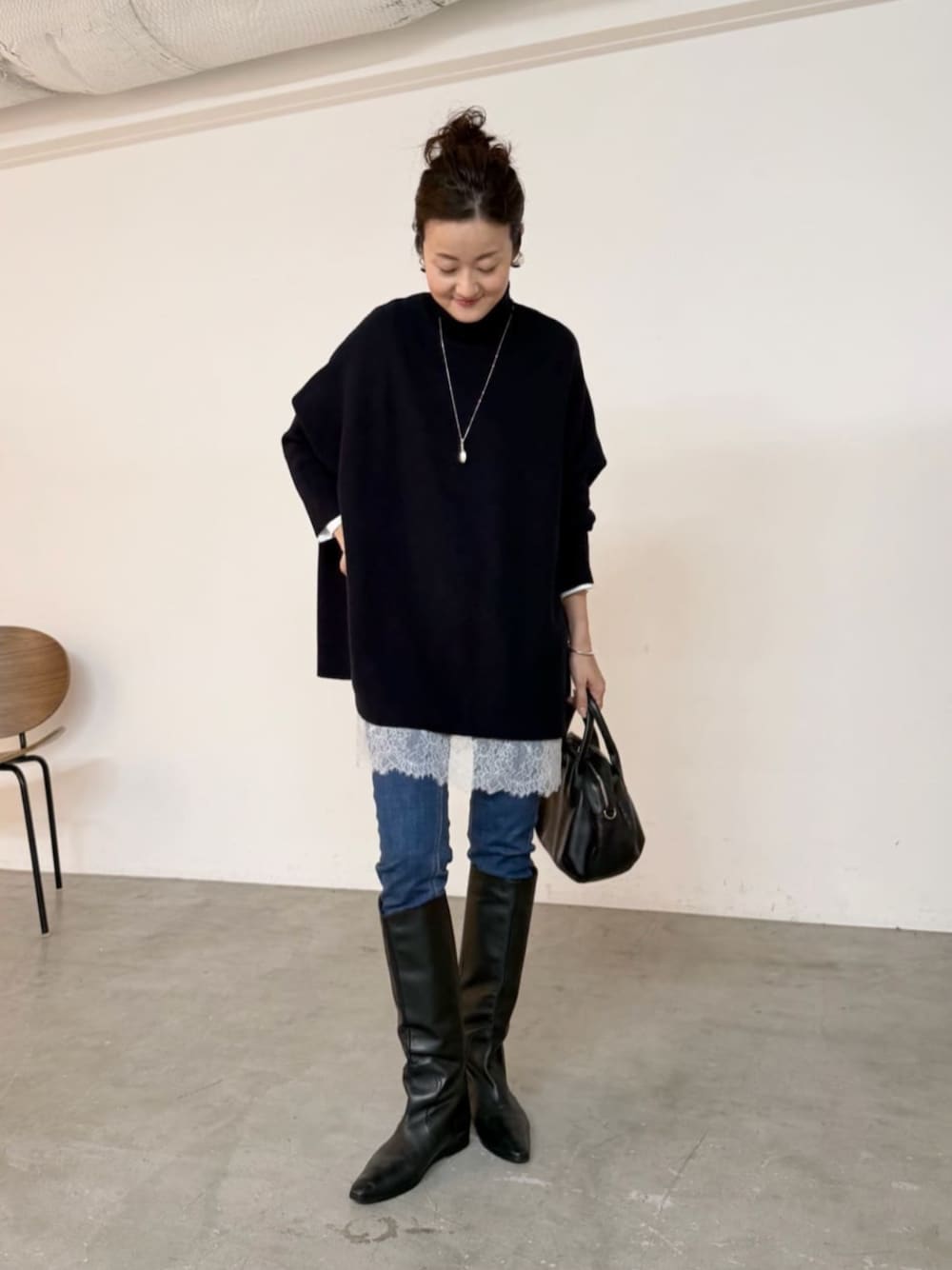 ブルー系のデニムパンツ、ブラック系のトートバッグ、ホワイト系のTシャツ/カットソーを着用したレディースの秋コーディネートの1枚目の写真