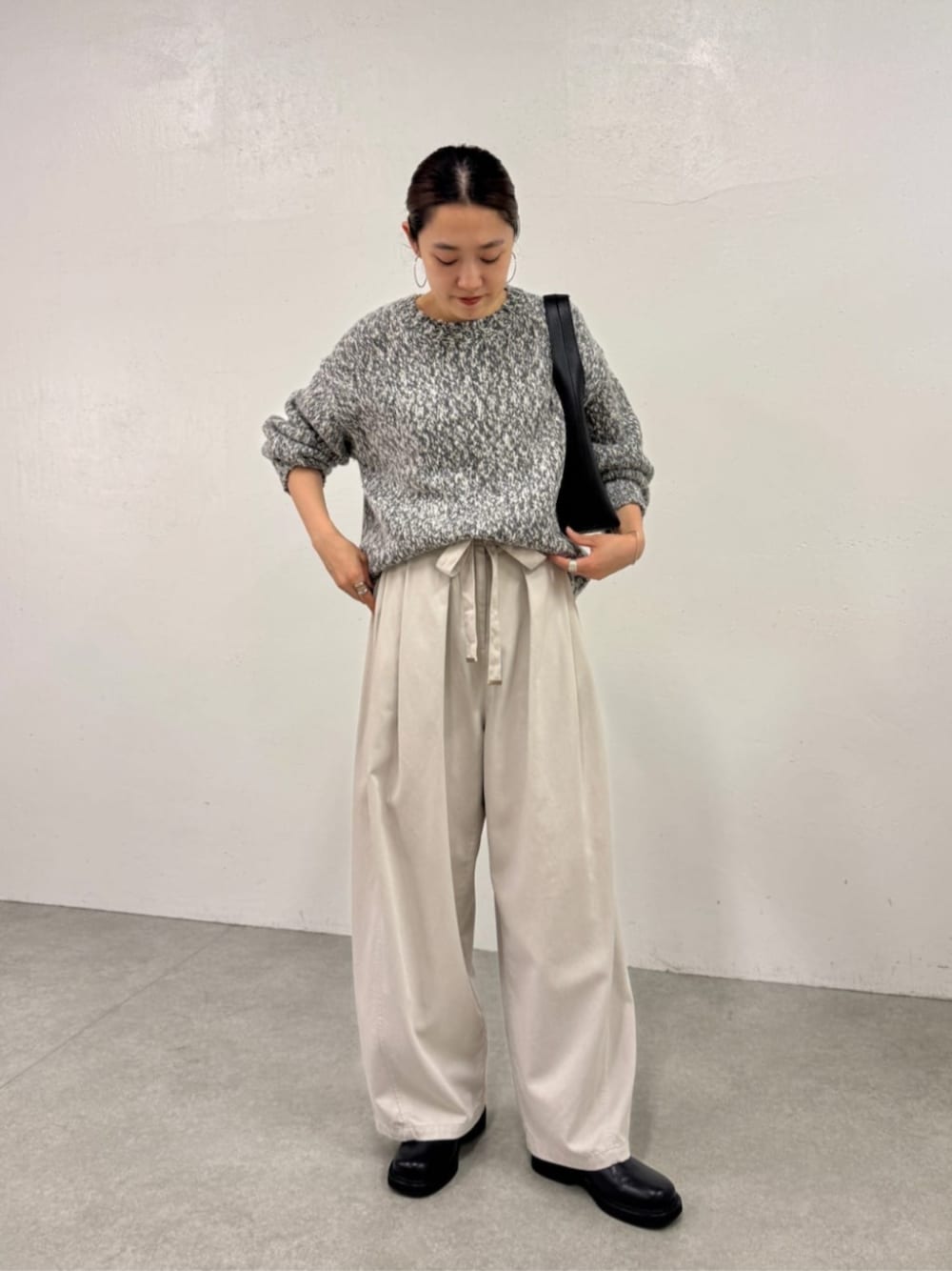 ブラック系のローファー、ホワイト系のその他パンツ、グレー系のニット/セーターを着用したレディースの秋コーディネートの1枚目の写真