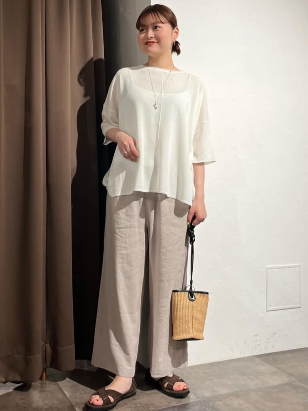 グレー系のその他パンツ、ホワイト系のニット/セーターを着用したレディースの夏コーディネートの1枚目の写真