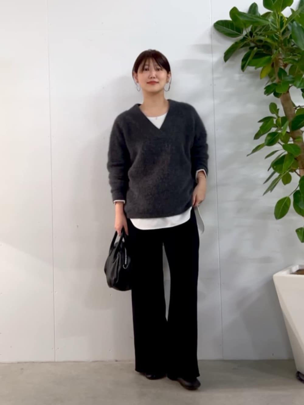 ブラック系のトートバッグ、グレー系のニット/セーター、ホワイト系のシャツ/ブラウスを着用したレディースの秋コーディネートの1枚目の写真