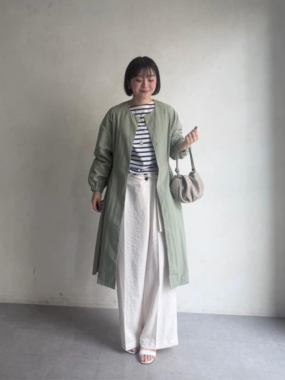 グリーン系のその他アウター、ホワイト系のその他パンツ、ホワイト系のTシャツ/カットソーを着用したレディースの冬コーディネートの1枚目の写真