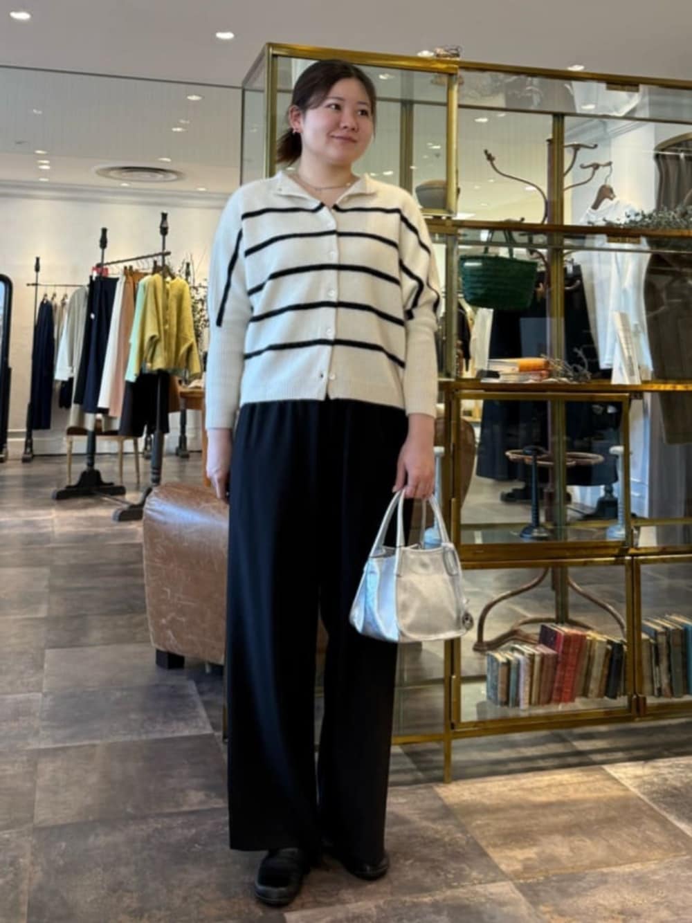 ホワイト系のニット/セーター、シルバー系のトートバッグ、ブラック系のその他パンツを着用したレディースの冬コーディネートの1枚目の写真