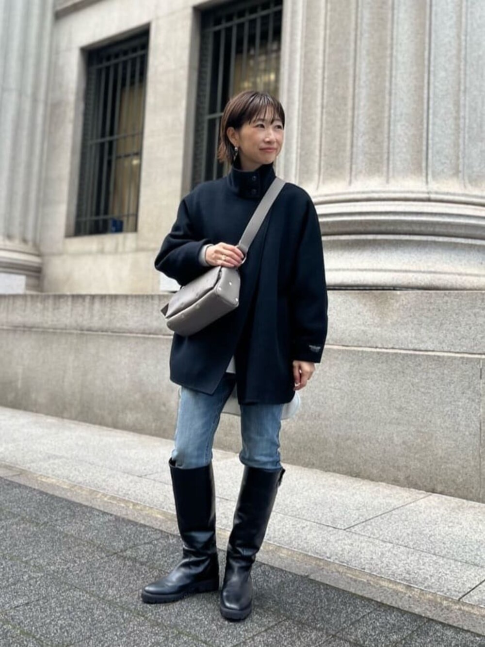 ブルー系のデニムパンツ、ブラック系のその他アウター、グレー系のショルダーバッグを着用したレディースの秋コーディネートの1枚目の写真