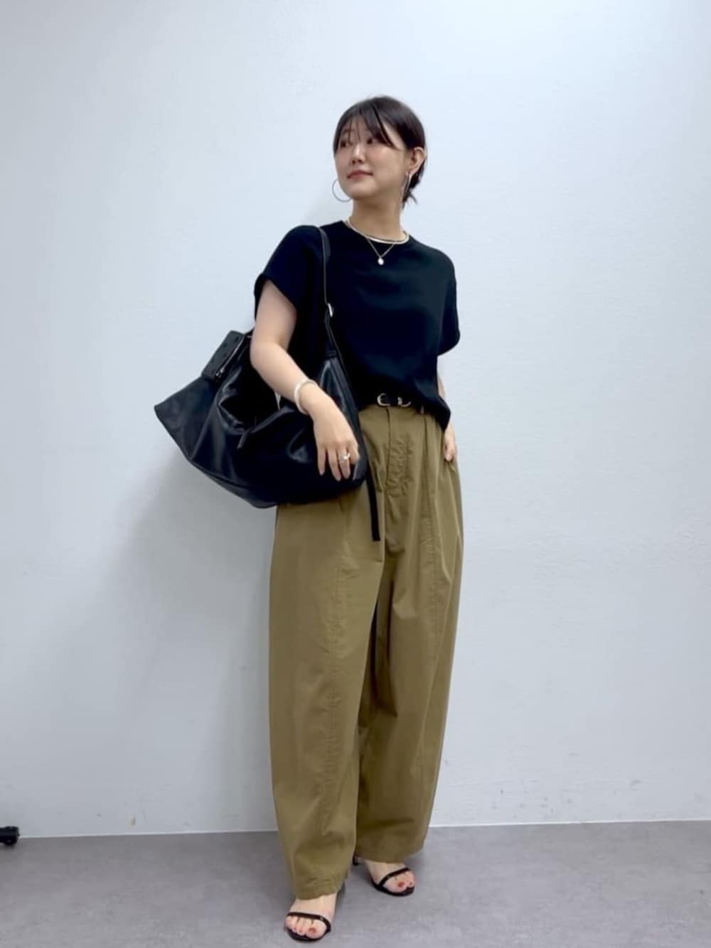 イエロー系のその他パンツ、ブラック系のニット/セーターを着用したレディースの夏コーディネートの1枚目の写真