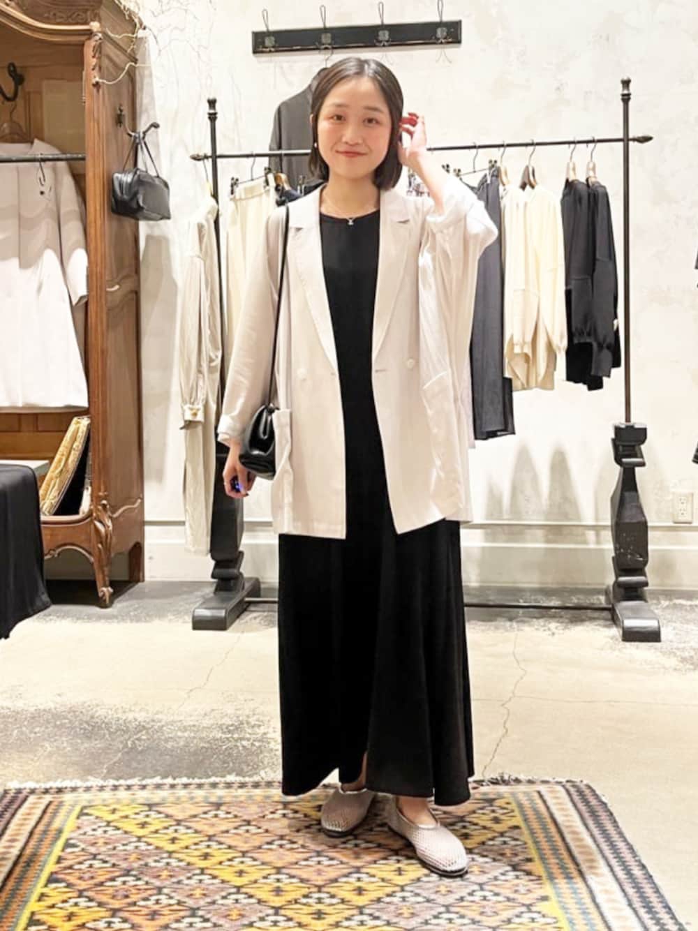 ブラック系のトートバッグ、ベージュ系のテーラードジャケット、ブラック系のワンピースを着用したレディースの夏コーディネートの1枚目の写真