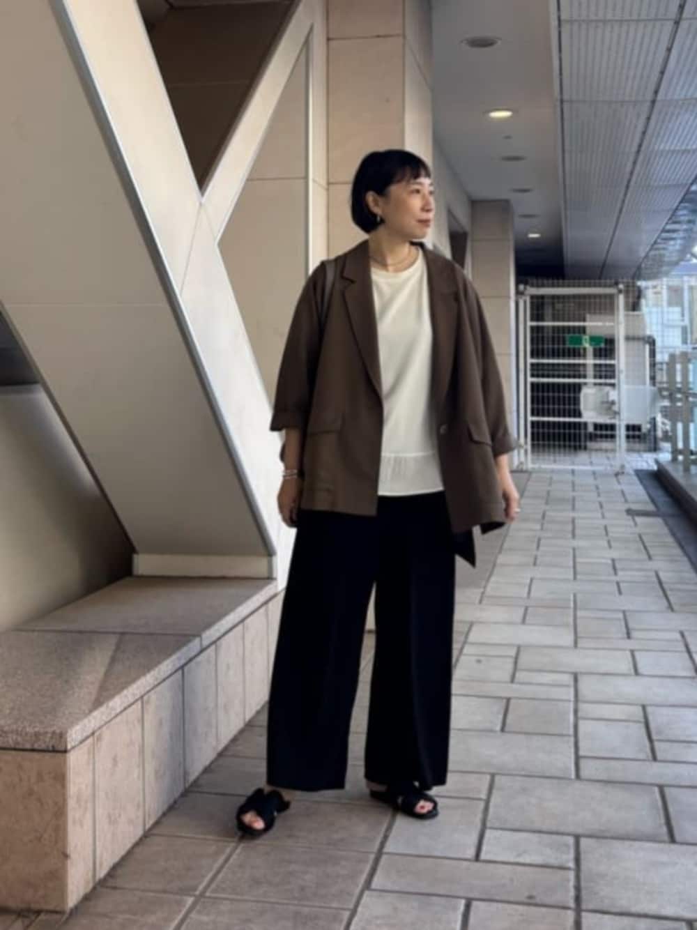ブラック系のその他パンツ、ブラウン系のテーラードジャケット、ホワイト系のTシャツ/カットソーを着用したレディースの春コーディネートの1枚目の写真