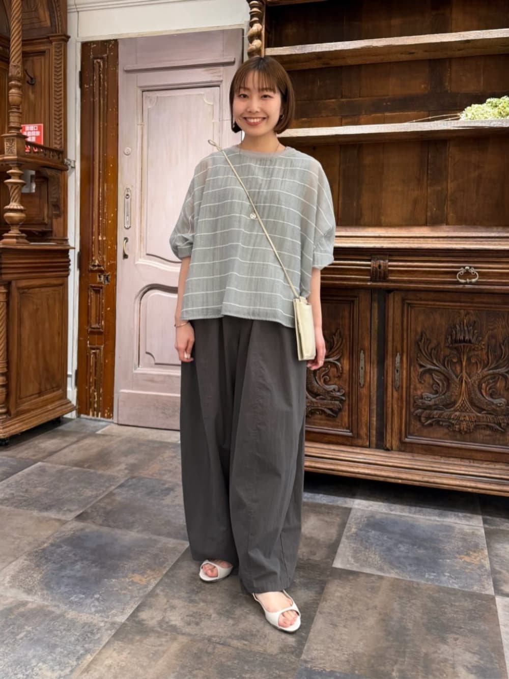 ホワイト系のショルダーバッグ、グレー系のシャツ/ブラウス、グレー系のその他パンツを着用したレディースの春コーディネートの1枚目の写真
