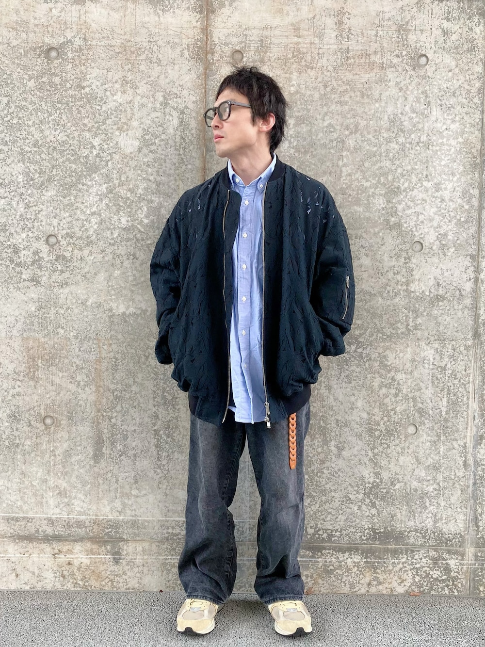 ブラック系のデニムパンツ、ベージュ系のスニーカー、ブラック系のブルゾンを着用したメンズの春コーディネートの1枚目の写真