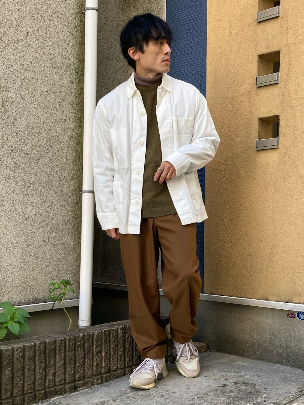 ブラウン系のパンツ、ブラウン系のTシャツ/カットソー、ホワイト系のブルゾンを着用したメンズの冬コーディネートの1枚目の写真