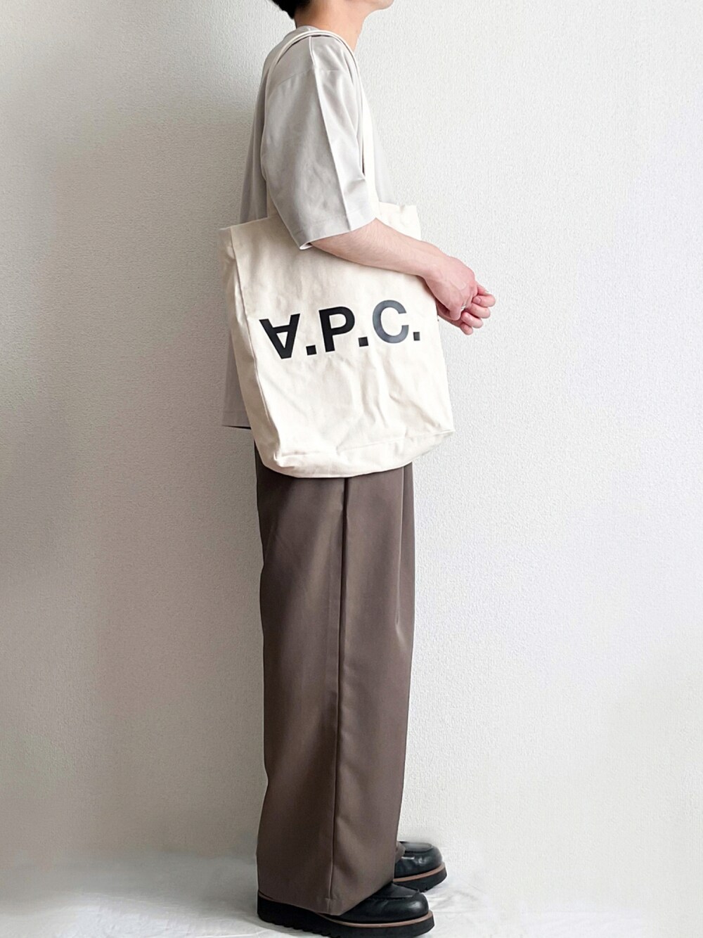 ホワイト系のトートバッグ、ホワイト系のTシャツ/カットソー、ブラウン系のその他パンツを着用したメンズの夏コーディネートの1枚目の写真