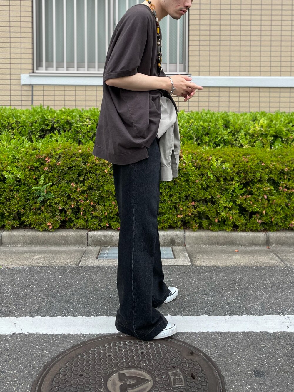 ブラック系のデニムパンツ、ブラウン系のTシャツ/カットソーを着用したメンズの夏コーディネートの1枚目の写真